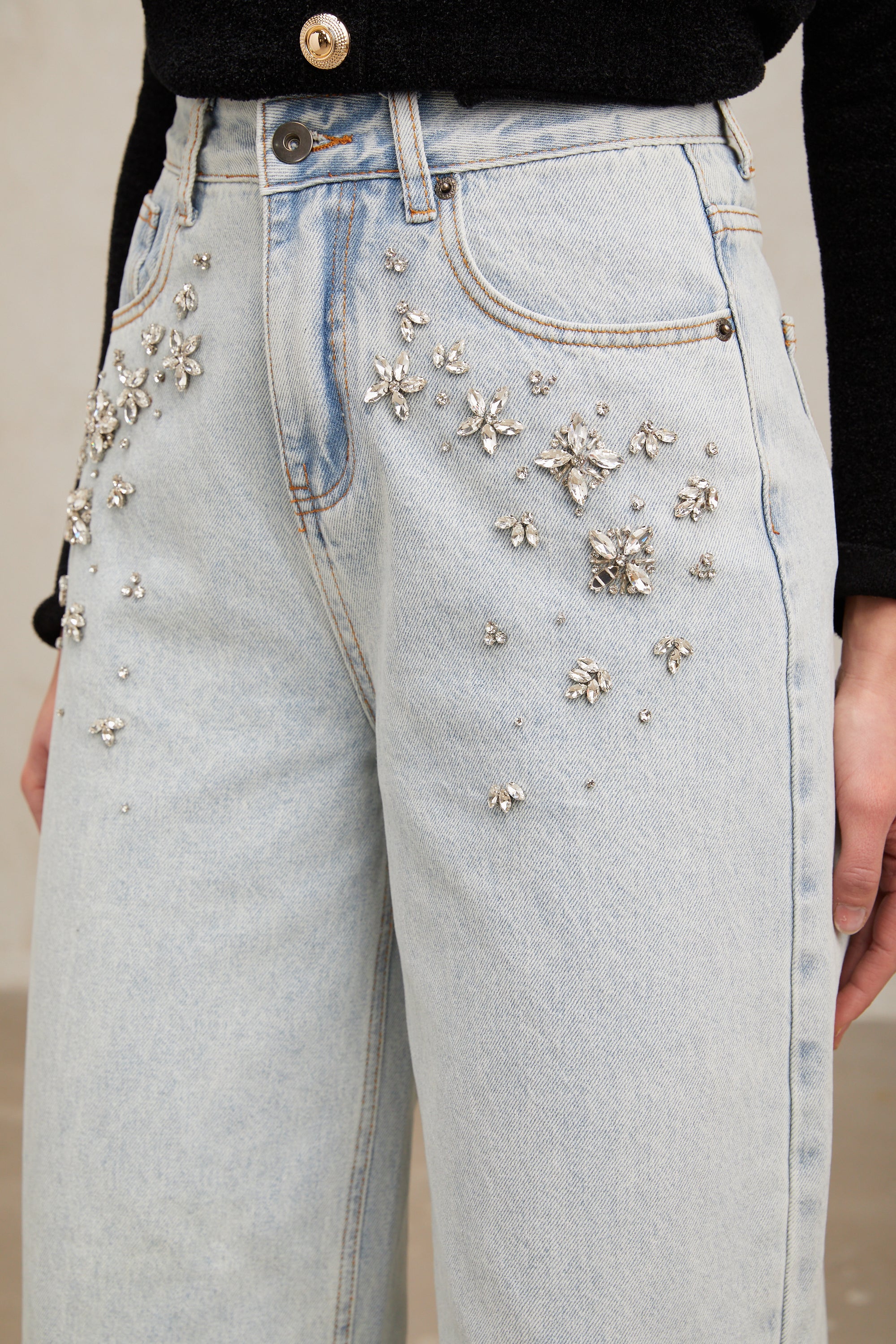 Women's light blue wide-leg denim jeans with crystal embellishment on hip pockets
