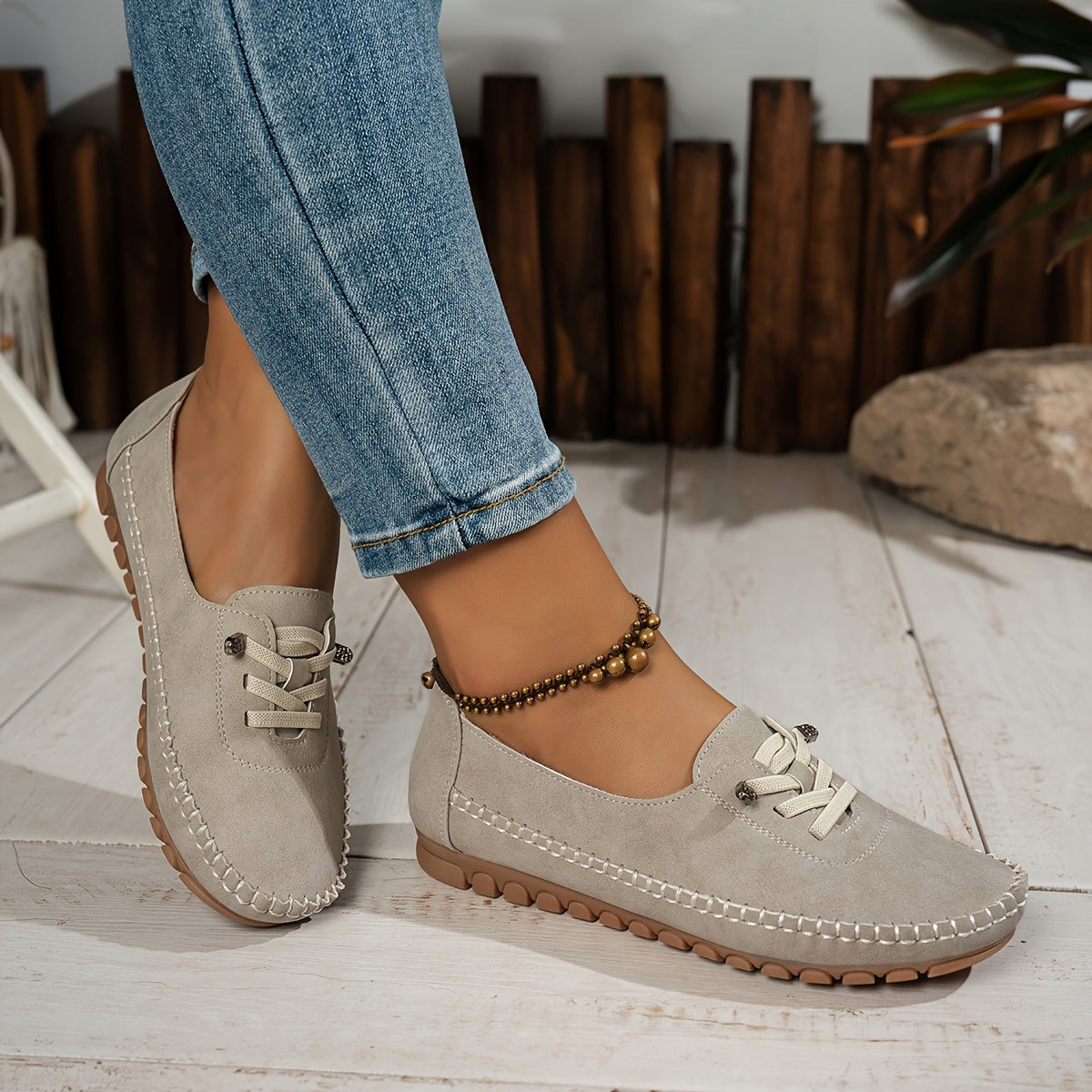 Women's grey and beige lace-up moccasin loafers with cushioned sole, worn with jeans
