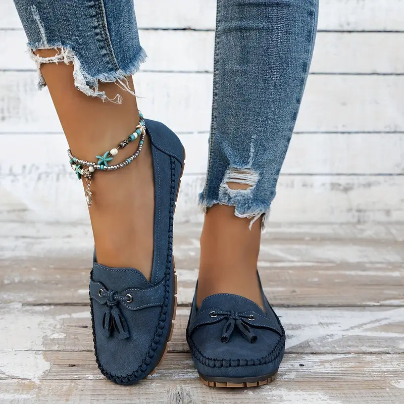Women's navy loafer with tassel detail, moccasin sole, worn with ripped jeans