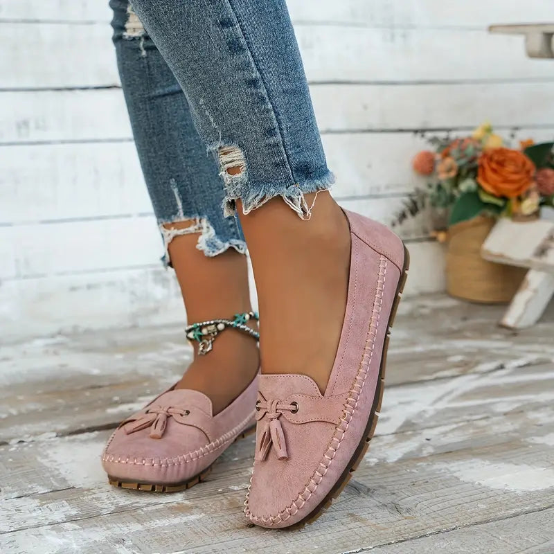 Women's navy loafer with tassel detail, moccasin sole, worn with ripped jeans