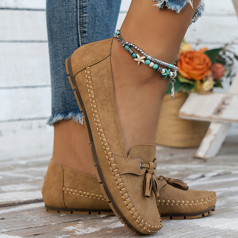 Women's navy loafer with tassel detail, moccasin sole, worn with ripped jeans