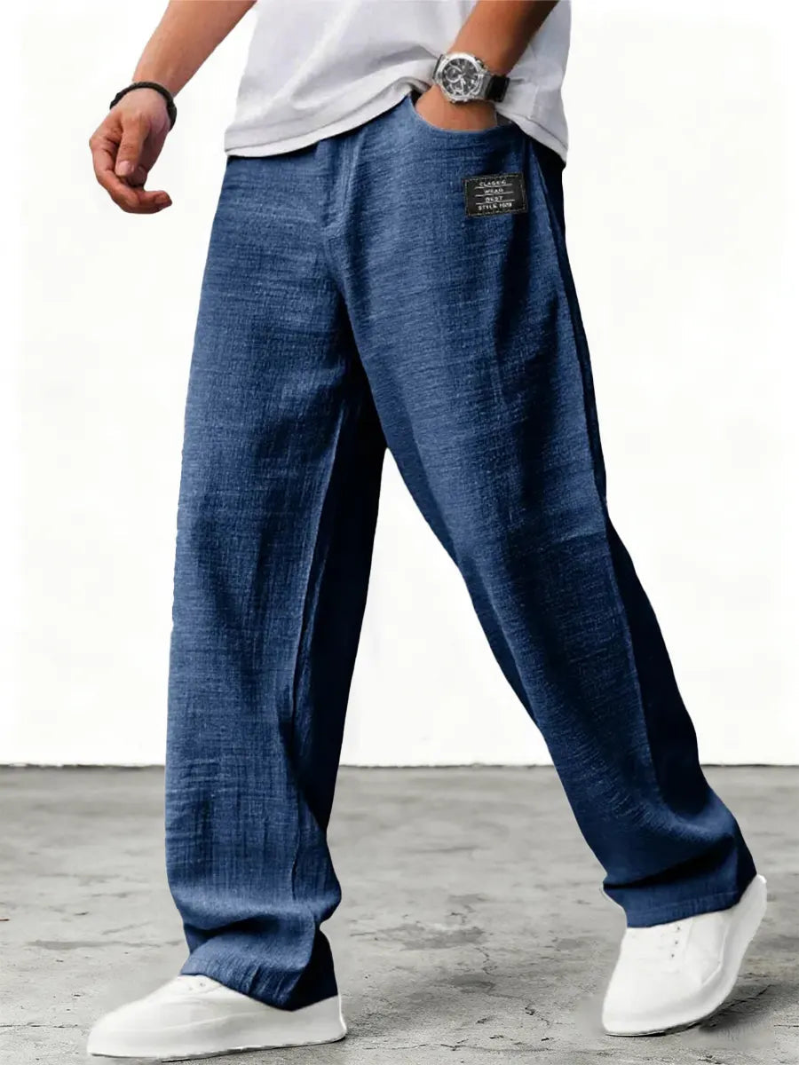 Man wearing blue wide leg relaxed fit trousers with white sneakers