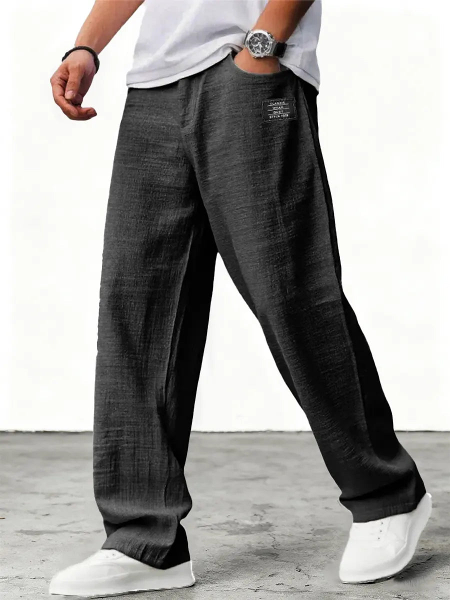 Man wearing blue wide leg relaxed fit trousers with white sneakers
