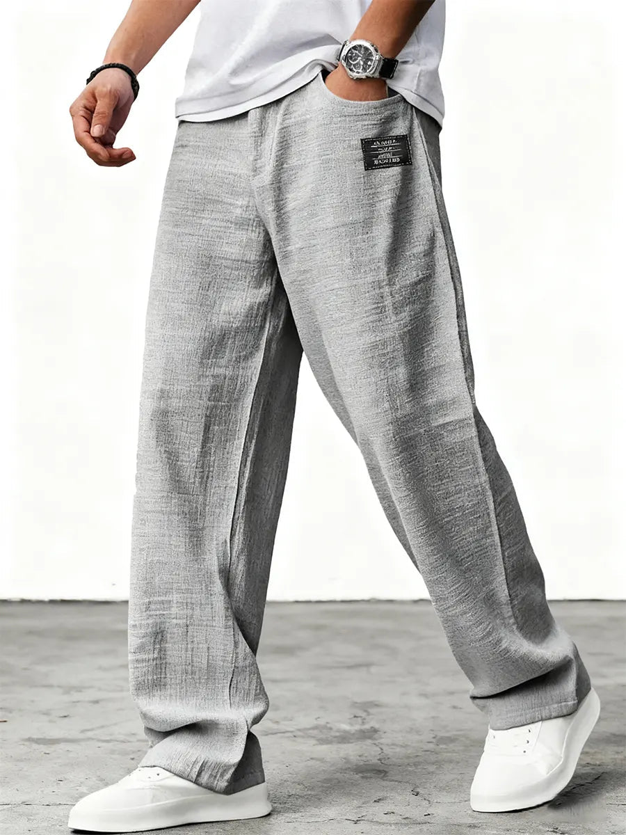 Man wearing blue wide leg relaxed fit trousers with white sneakers