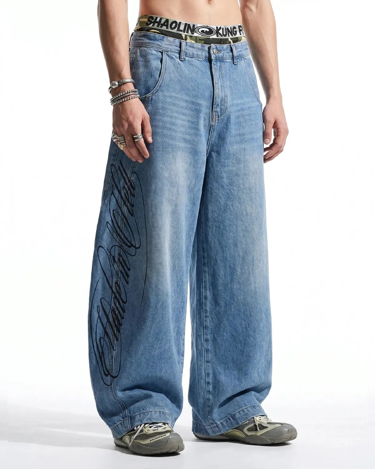 Light blue barrel-leg jeans with black script graphic and five-pocket design