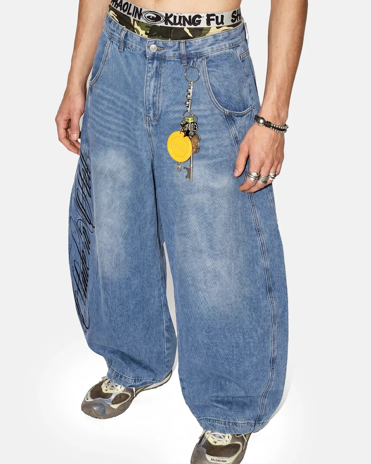 Light blue barrel-leg jeans with black script graphic and five-pocket design