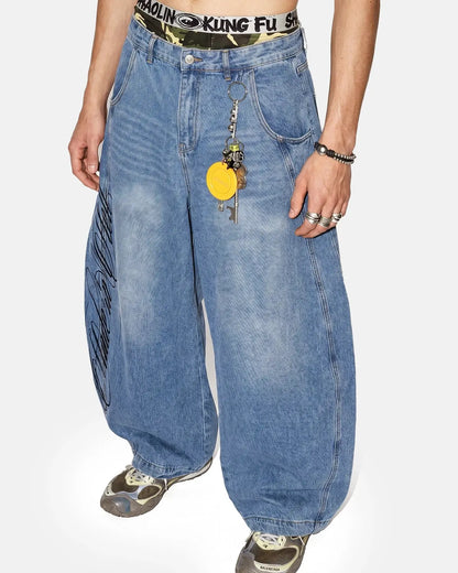 Light blue barrel-leg jeans with black script graphic and five-pocket design