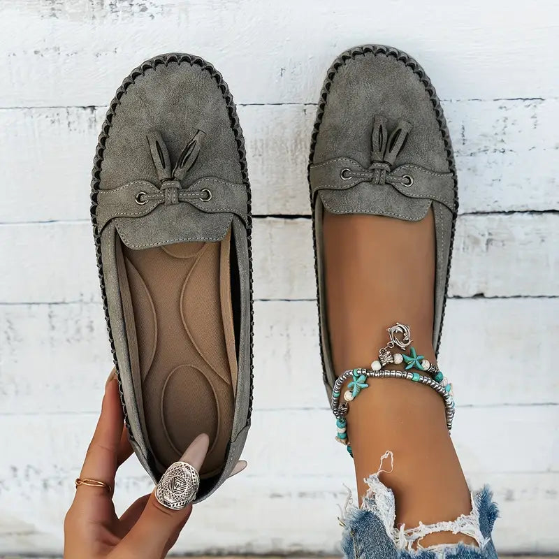 Women's navy loafer with tassel detail, moccasin sole, worn with ripped jeans