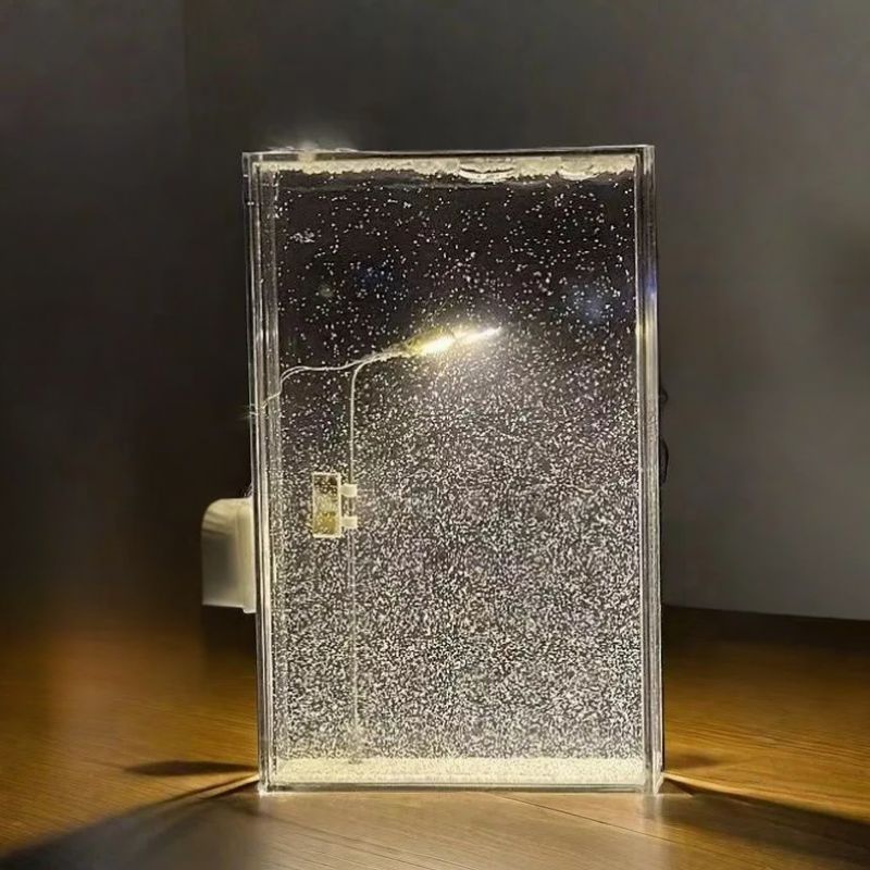 Clear rectangular bubble display lamp standing on a wooden table