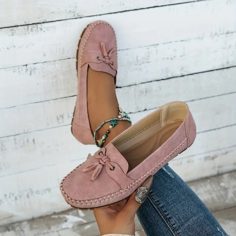 Women's navy loafer with tassel detail, moccasin sole, worn with ripped jeans