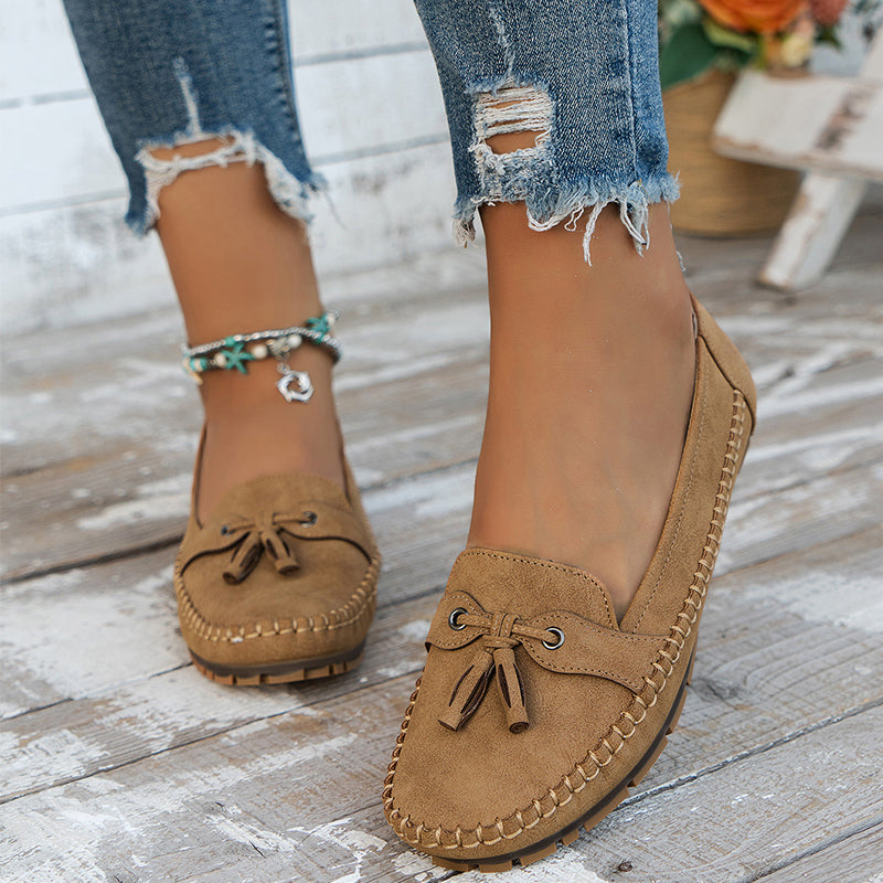 Women's navy loafer with tassel detail, moccasin sole, worn with ripped jeans