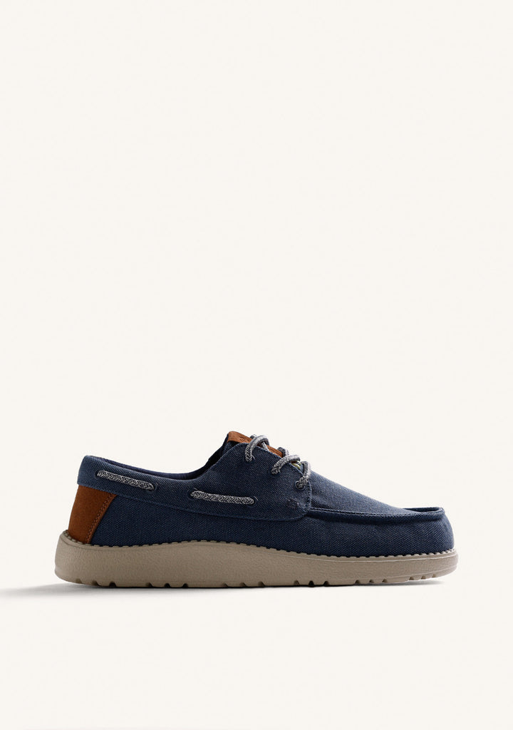 Navy Wallabee loafers with grey laces, brown heel detail and flat textured soles