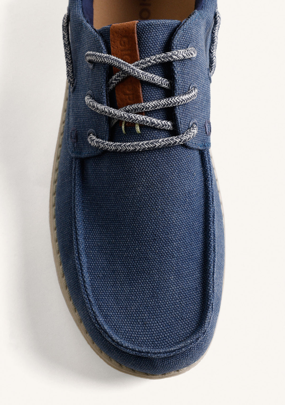 Navy Wallabee loafers with grey laces, brown heel detail and flat textured soles