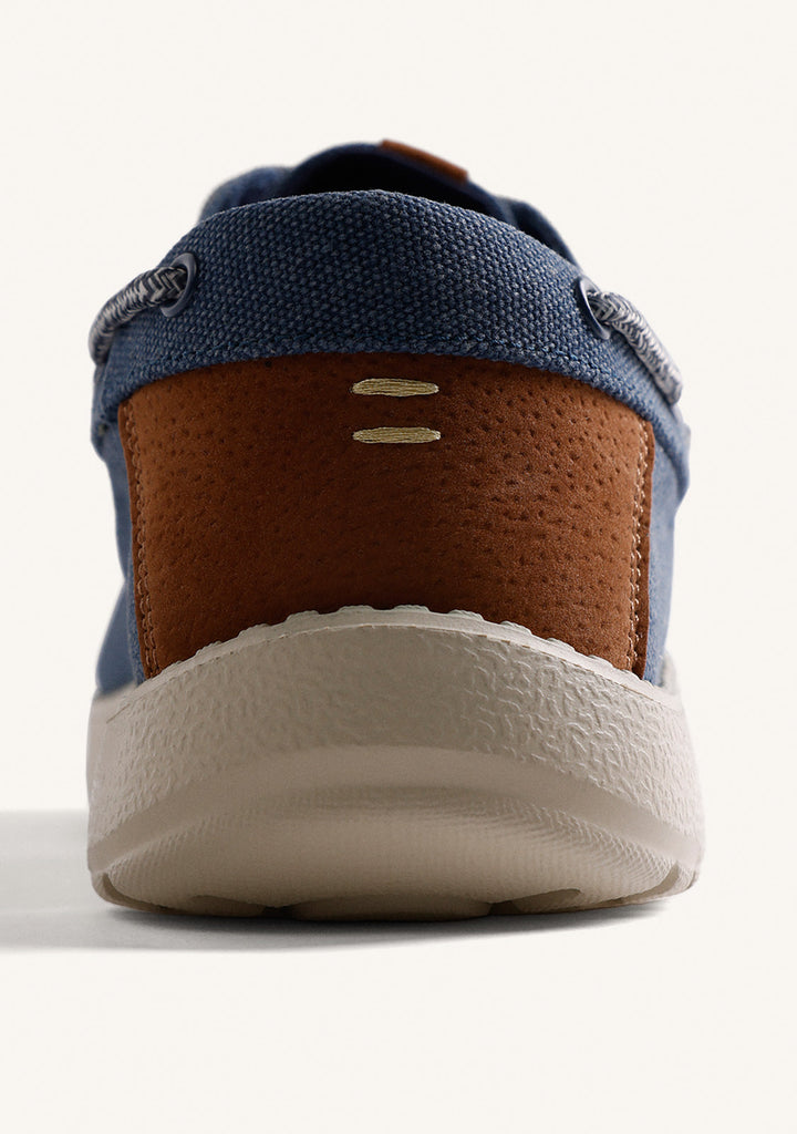 Navy Wallabee loafers with grey laces, brown heel detail and flat textured soles