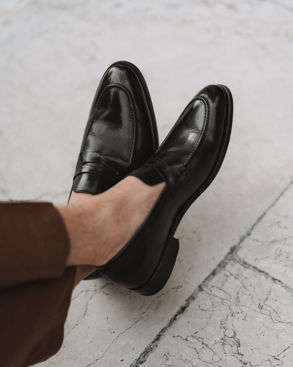 Black polished penny loafers with almond toes and low heels