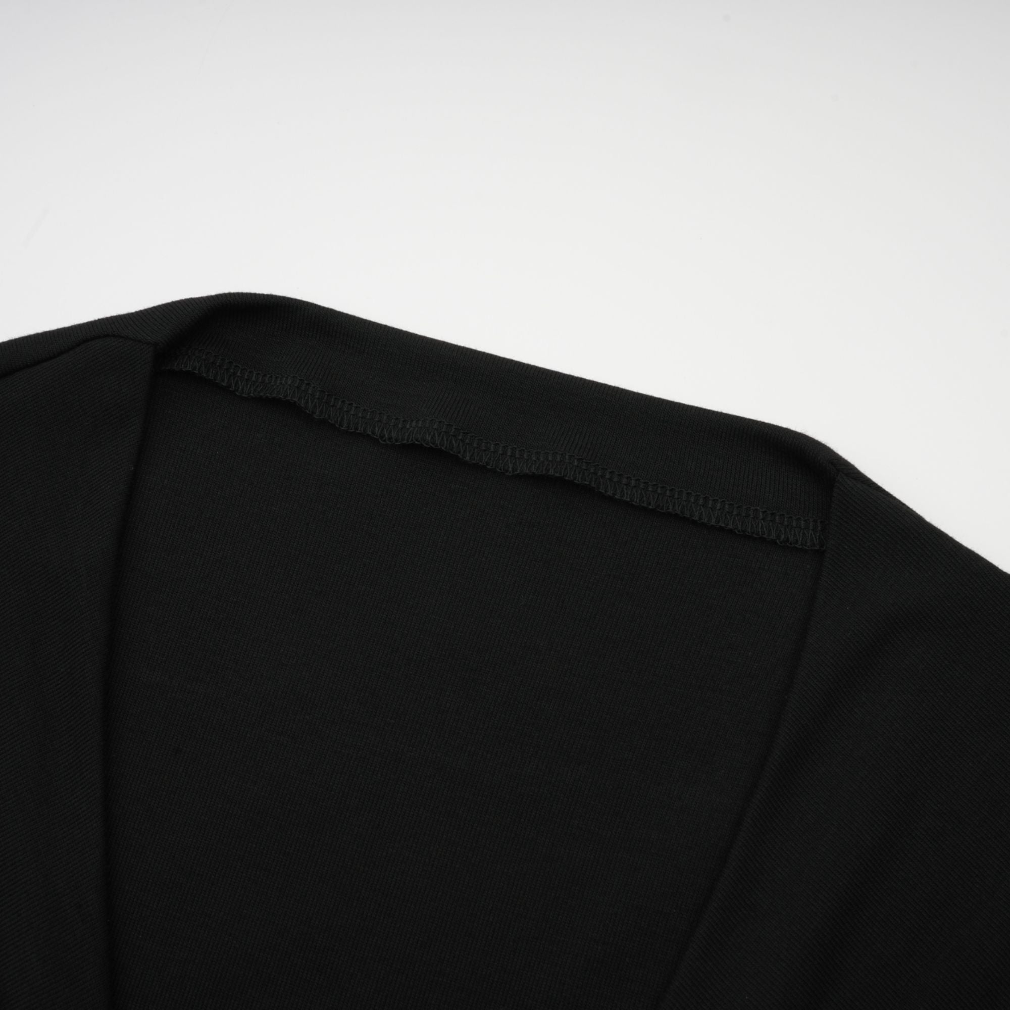 Women's black long sleeve fitted crop top with gathered ruching and open front cutout