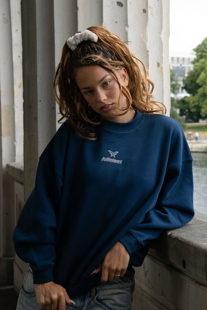 Navy crewneck sweatshirt with raised chest logo and ribbed trims