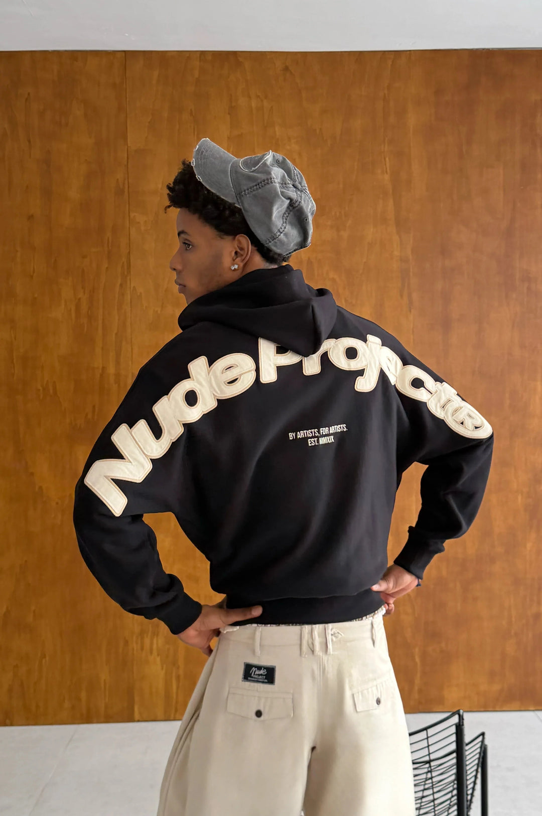 Black zip-up hoodie with hood and cream graphic on the back