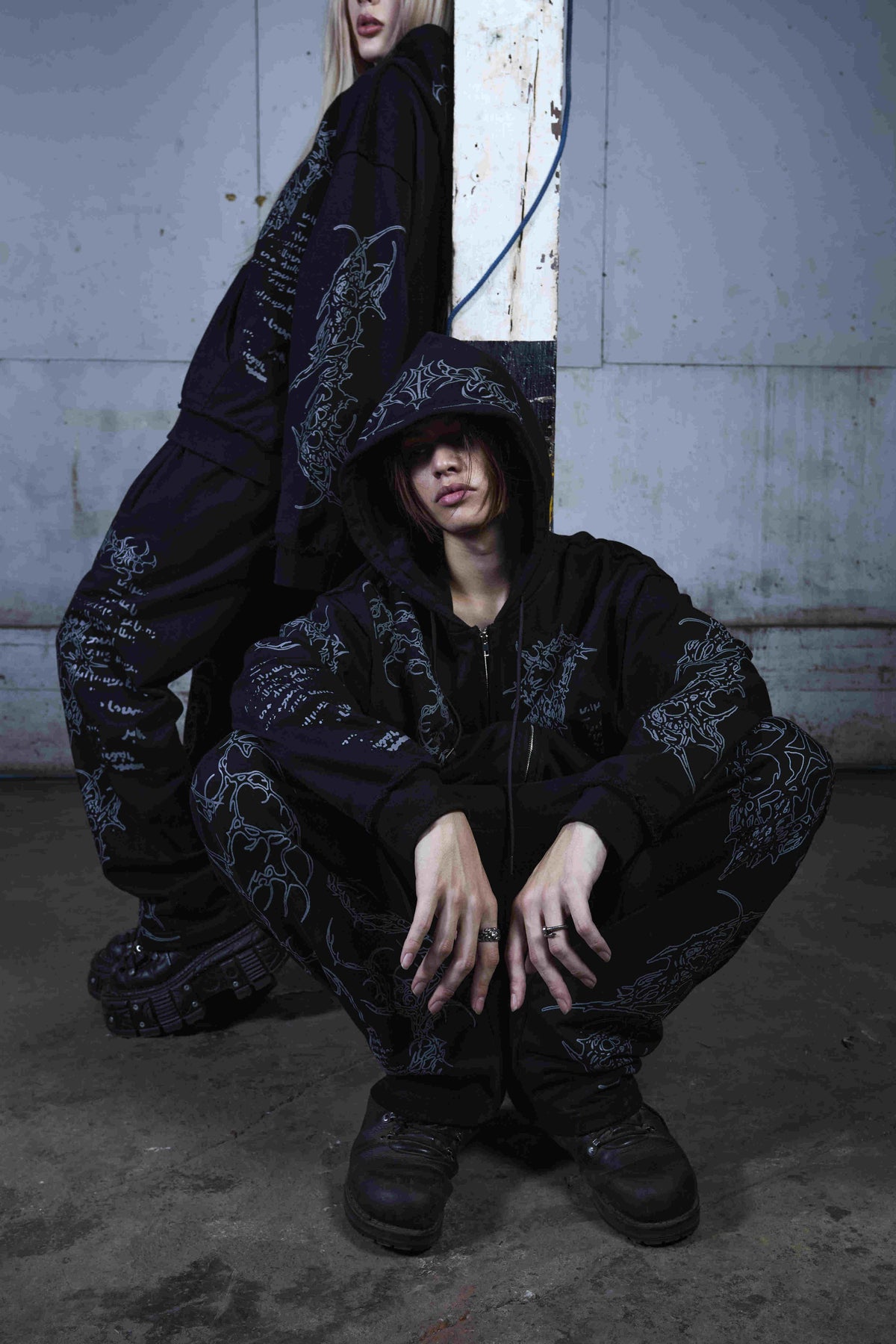 Black unisex zip hoodie with hood, long sleeves and contrasting graphic prints