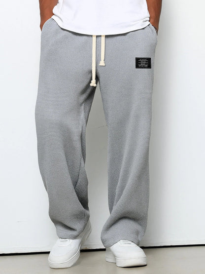 Men's wide leg textured trousers with drawstring waist, shown in blue and cream variants
