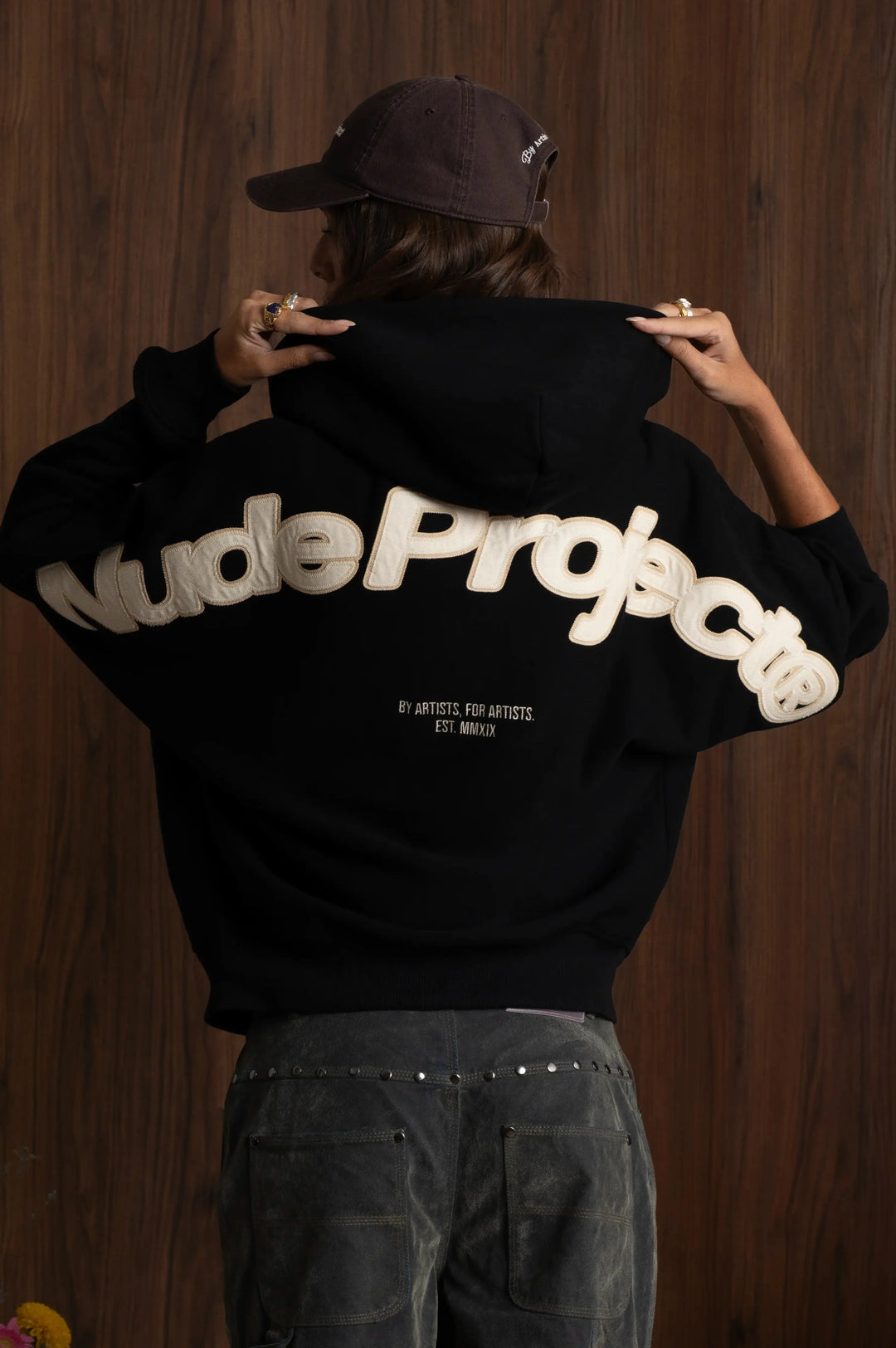 Black zip-up hoodie with hood and cream graphic on the back