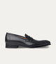 Black polished penny loafers with almond toes and low heels