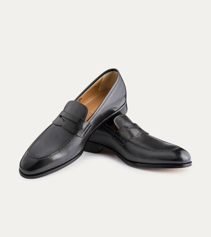 Black polished penny loafers with almond toes and low heels