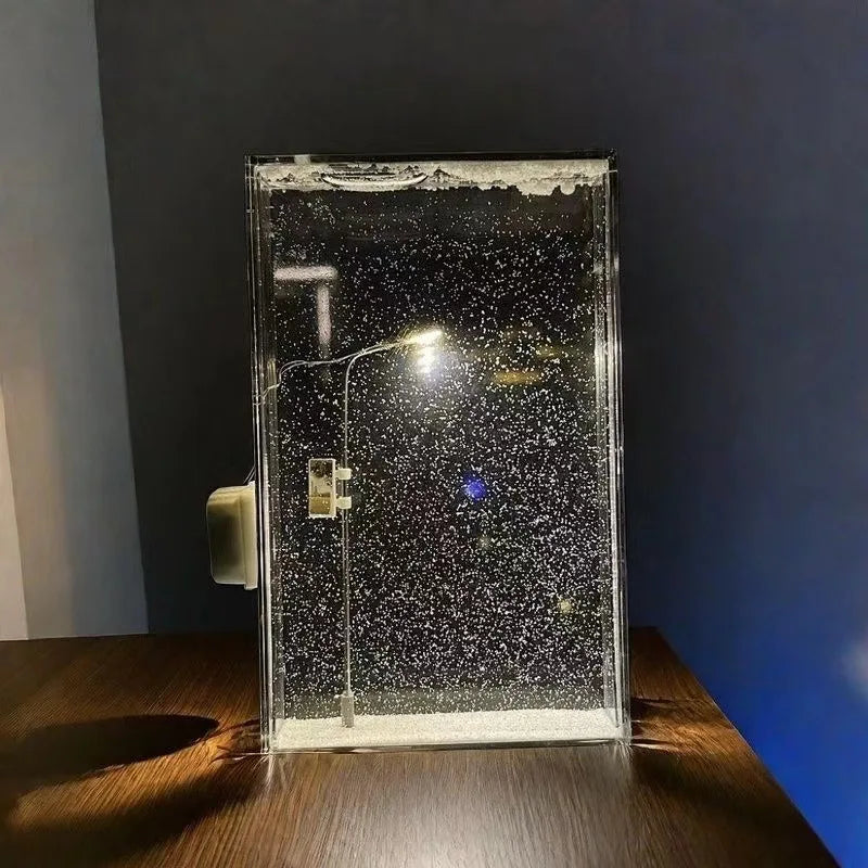 Clear rectangular bubble display lamp standing on a wooden table