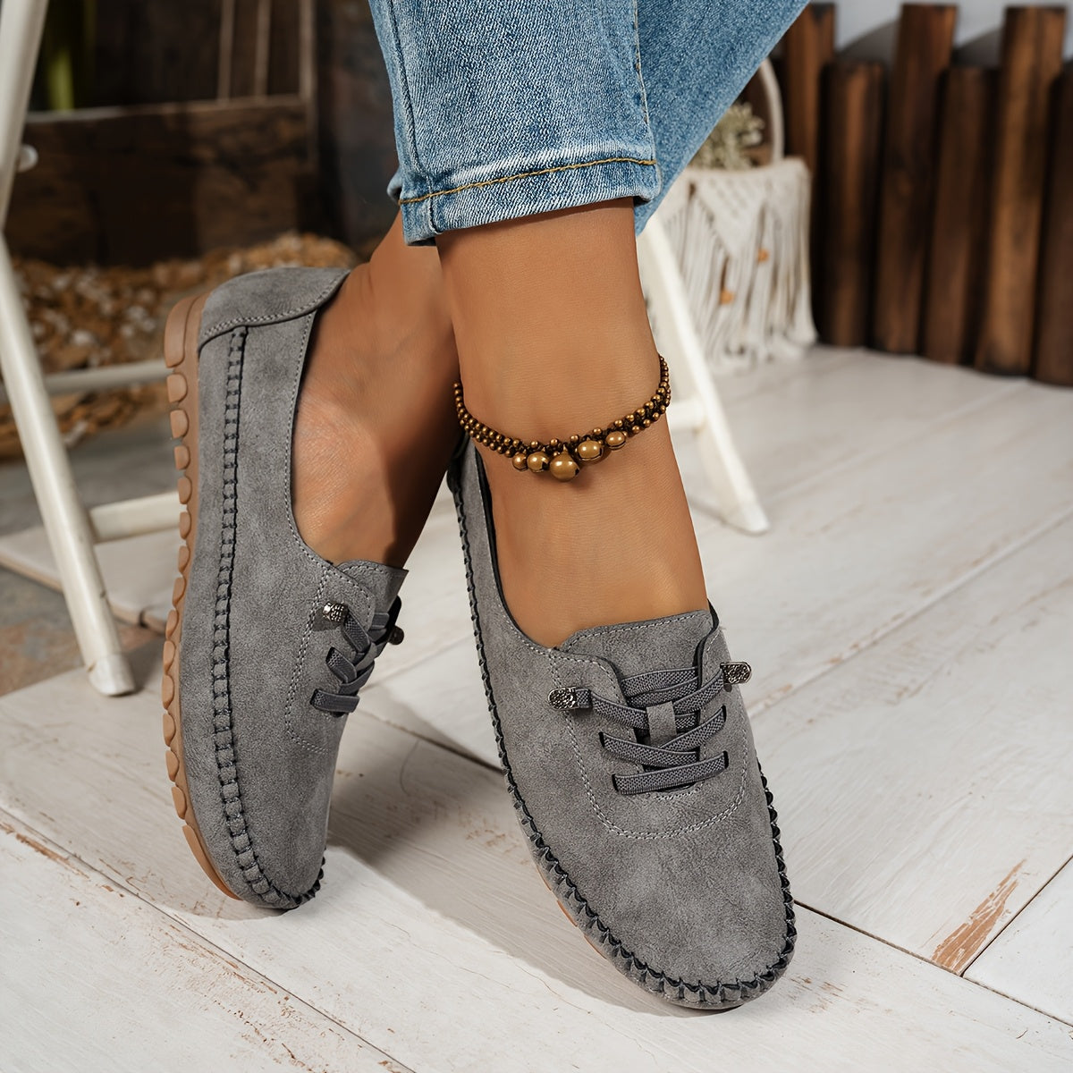 Women's grey and beige lace-up moccasin loafers with cushioned sole, worn with jeans