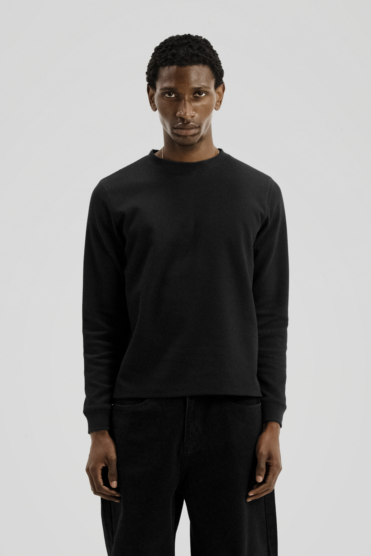Men's black long-sleeve crew-neck top with textured finish and ribbed cuffs