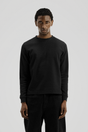 Men's black long-sleeve crew-neck top with textured finish and ribbed cuffs
