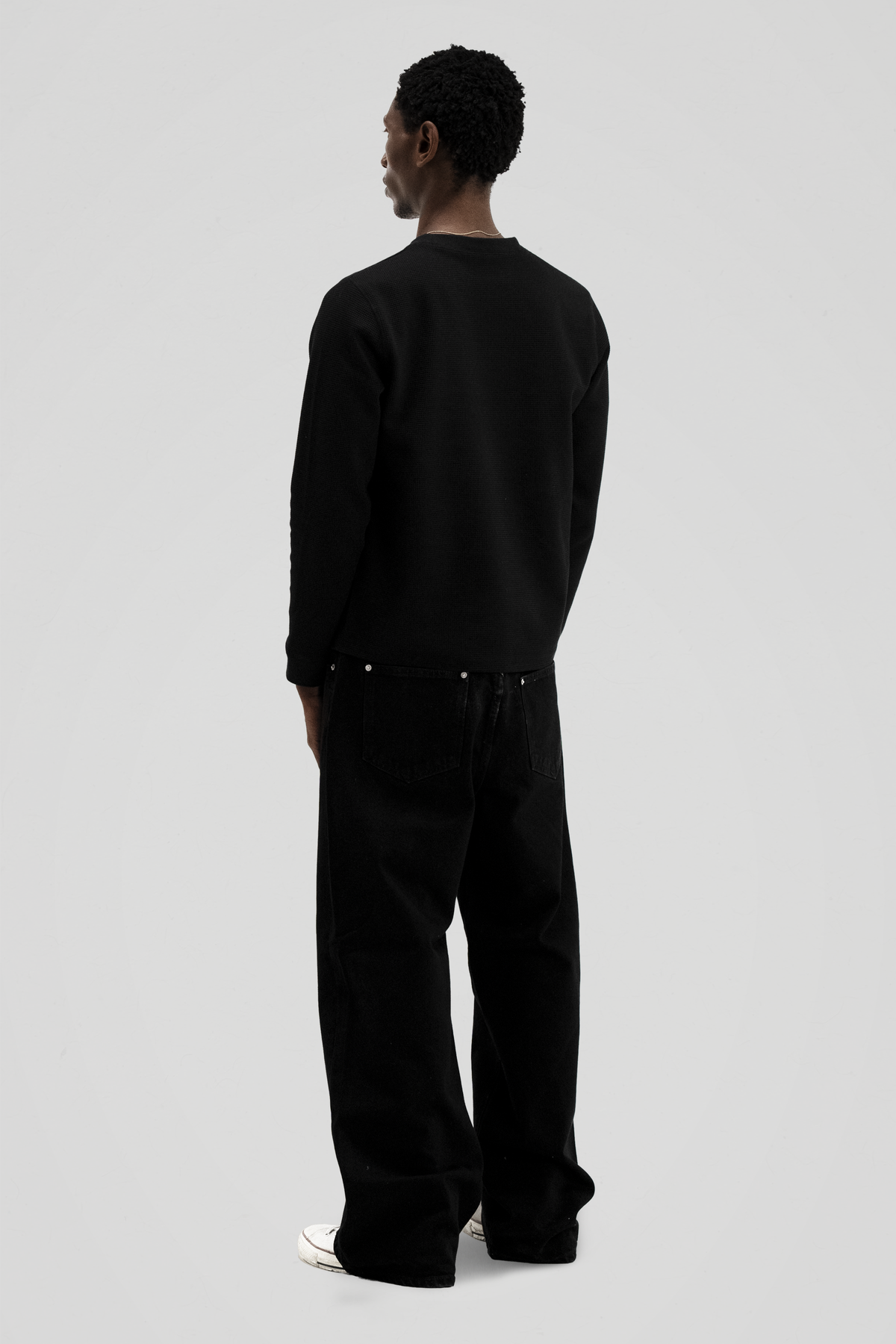 Men's black long-sleeve crew-neck top with textured finish and ribbed cuffs
