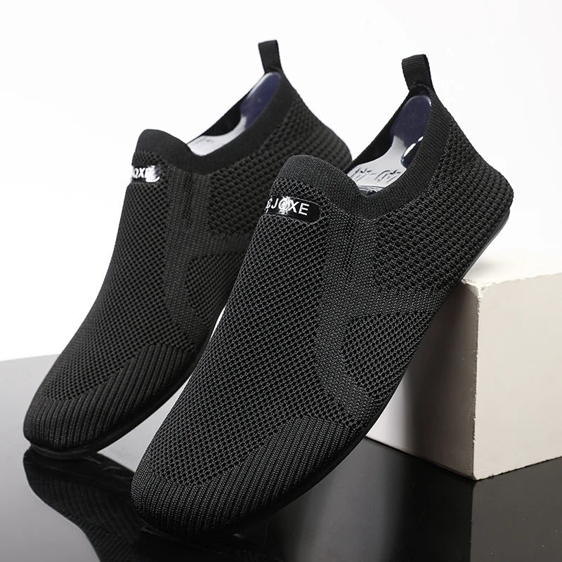 Knit slip-on shoes with round toes, pull tabs and flat soles