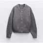 Grey knitted cardigan with a crew neck, front zip and long sleeves