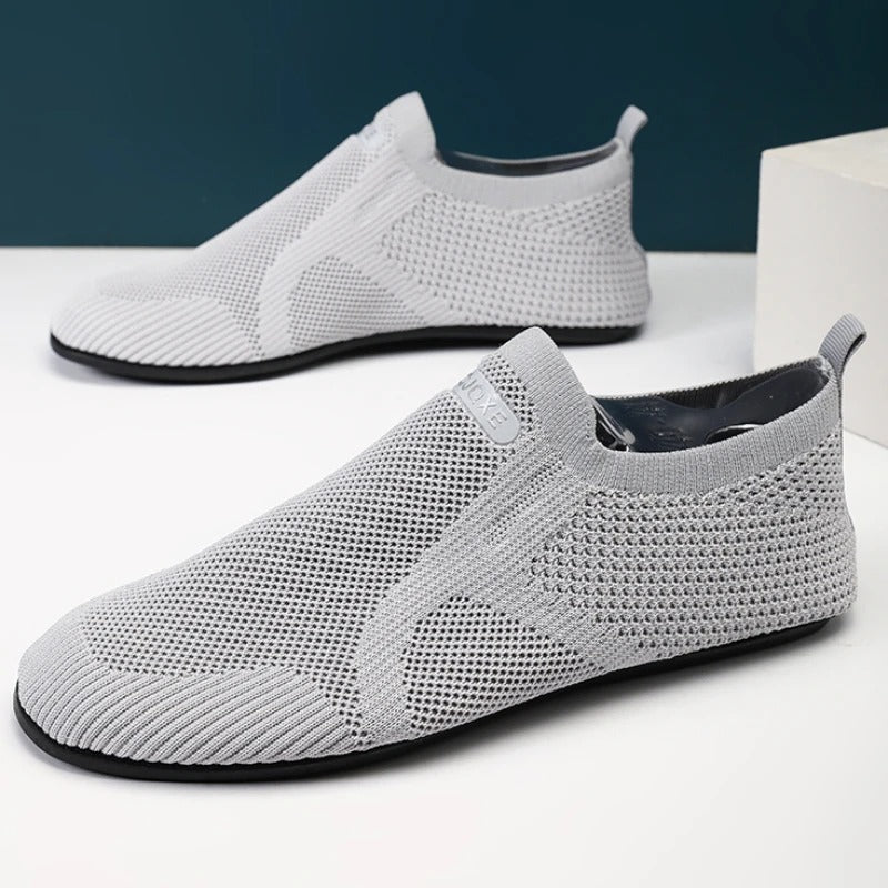 Knit slip-on shoes with round toes, pull tabs and flat soles