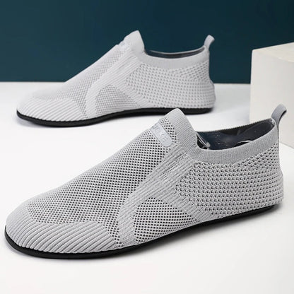 Knit slip-on shoes with round toes, pull tabs and flat soles