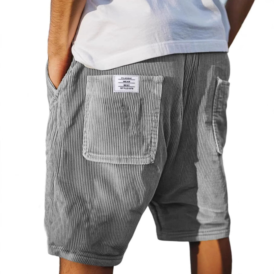 Men's grey ribbed shorts with stitched back pockets, shown from the rear on a model wearing a white t-shirt