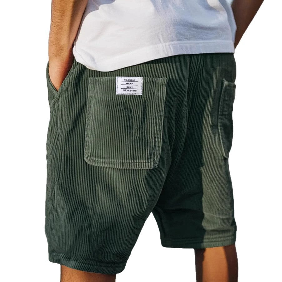 Men's grey ribbed shorts with stitched back pockets, shown from the rear on a model wearing a white t-shirt
