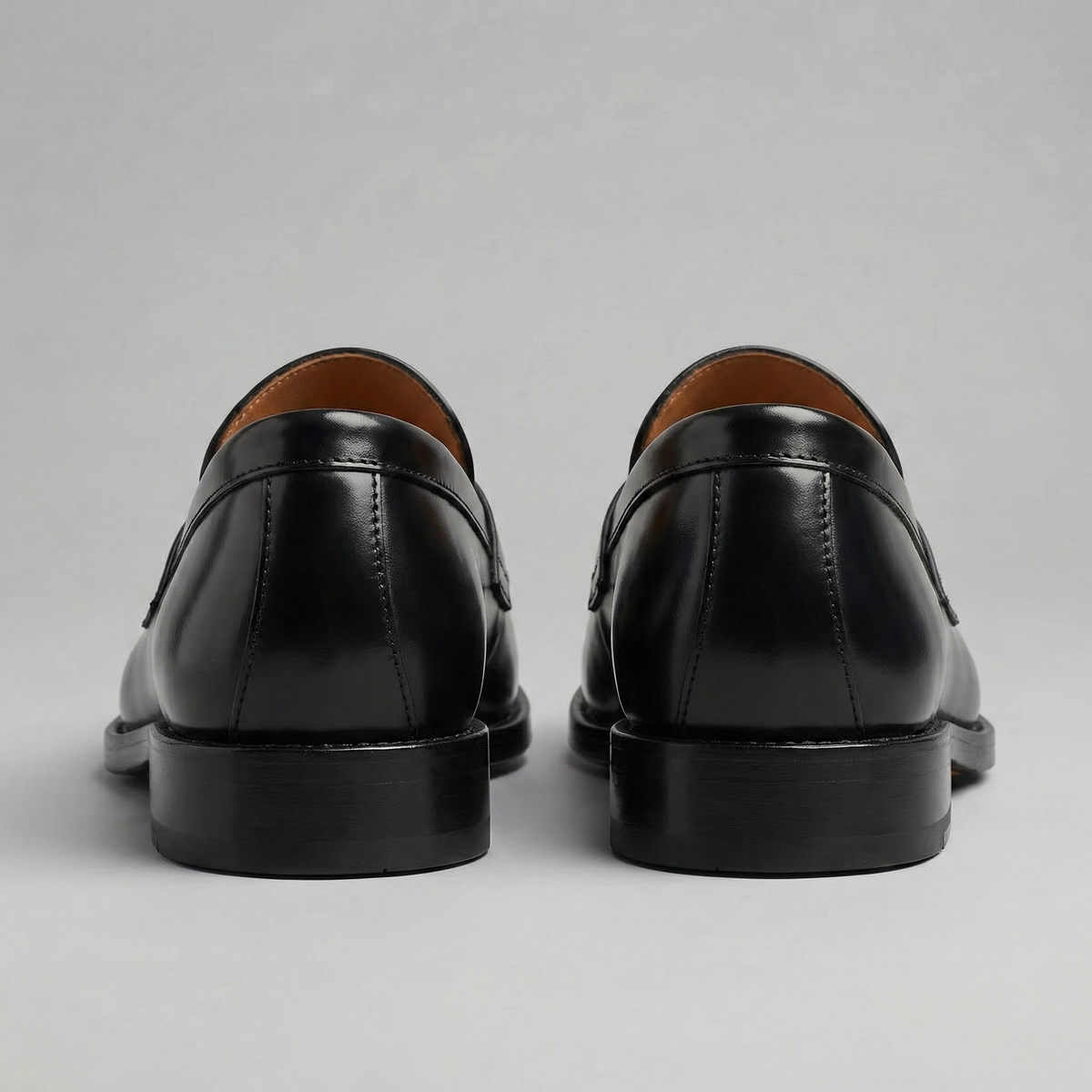 Men's black penny loafers with round toes and low block heels
