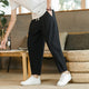 Men's tapered ankle pants with drawstring waist in cream, displayed with white sneakers