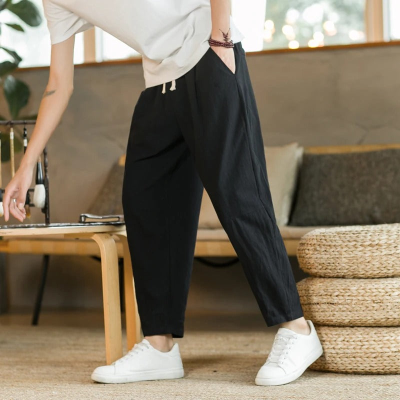 Men's tapered ankle pants with drawstring waist in cream, displayed with white sneakers