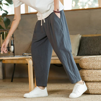 Men's tapered ankle pants with drawstring waist in cream, displayed with white sneakers