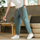 Men's tapered ankle pants with drawstring waist in cream, displayed with white sneakers