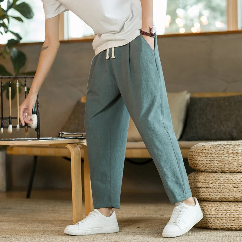 Men's tapered ankle pants with drawstring waist in cream, displayed with white sneakers