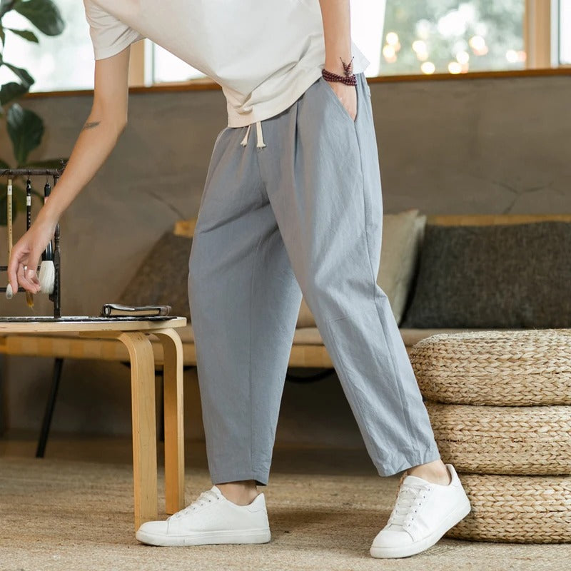 Men's tapered ankle pants with drawstring waist in cream, displayed with white sneakers