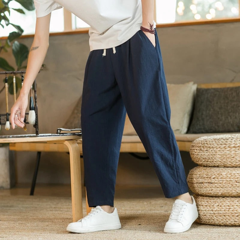 Men's tapered ankle pants with drawstring waist in cream, displayed with white sneakers