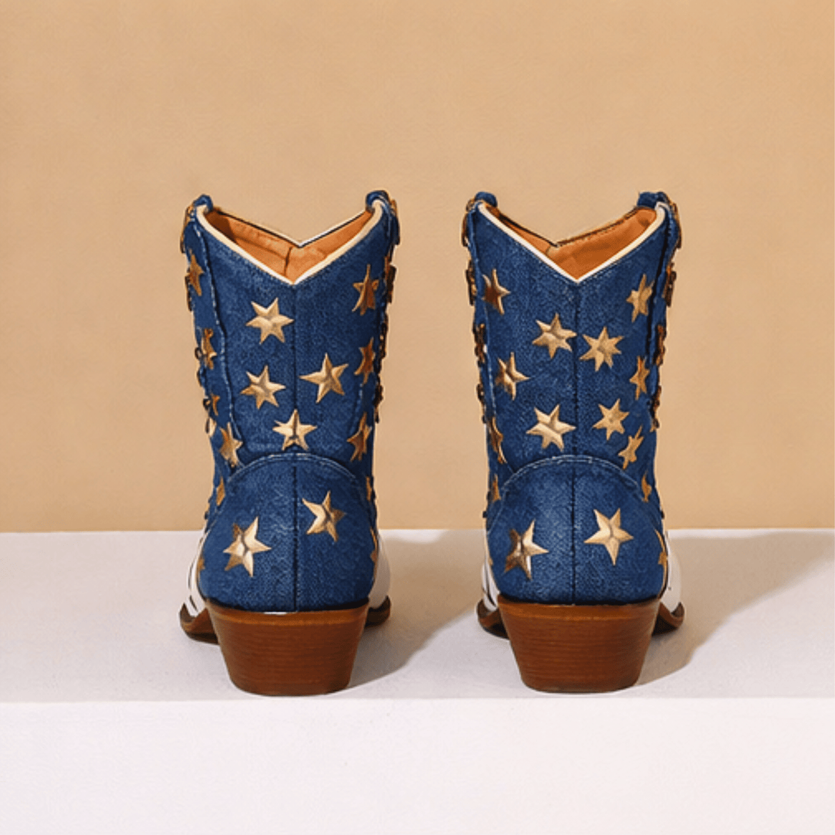 Ivory-white cowboy boots with red striped shafts, blue star panels and brown block heels