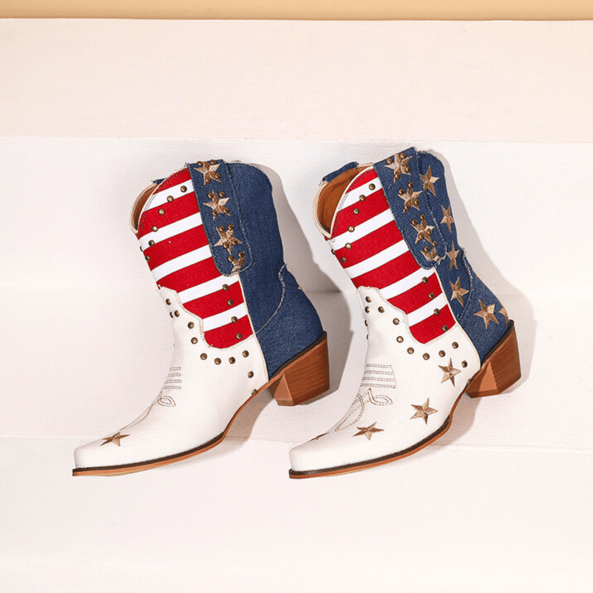 Ivory-white cowboy boots with red striped shafts, blue star panels and brown block heels